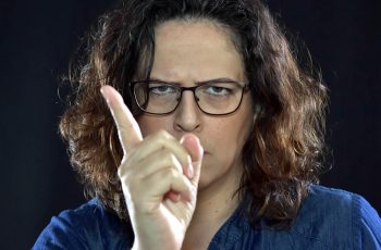 Angry woman in glasses with warning finger