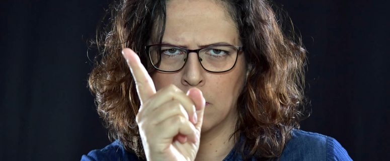Angry woman in glasses with warning finger