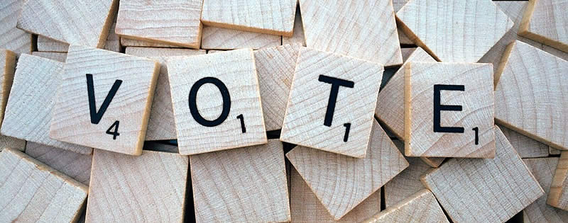 Scrabble tiles spelling VOTE - to change the world
