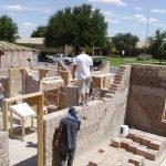 men building a compressed earth block home