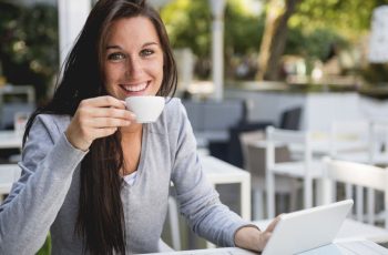 a woman drinking coffee smiles