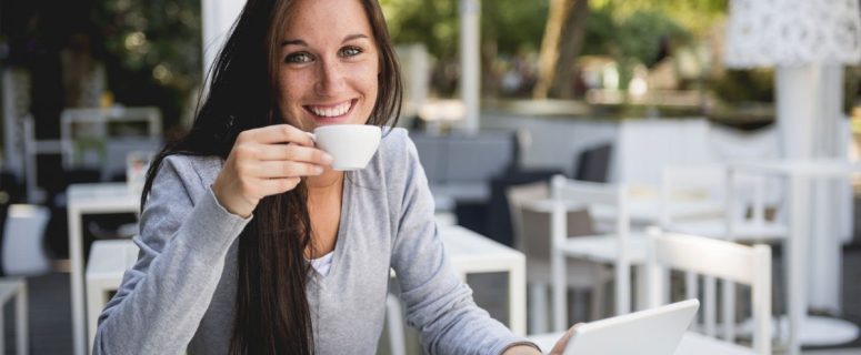 a woman drinking coffee smiles